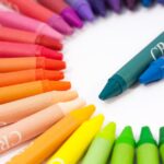 A vibrant semi-circle display of colorful crayons on a white background.